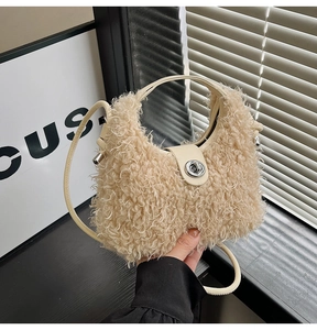 Detail of plush off-white crescent bag with silver twist lock and leather strap