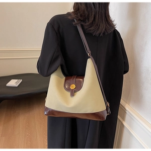 Detail of minimalist beige fabric and brown leather tote bag with metal N buckle