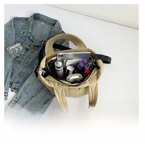 Spacious interior of light khaki quilted nylon tote bag with daily essentials inside