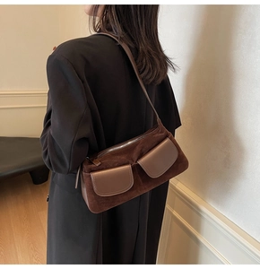 Close-up of retro dark brown suede shoulder bag showing texture contrast and pockets
