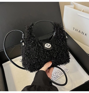Detail of black curly plush handbag featuring silver metal twist lock and leather strap
