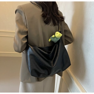 Black large hobo bag with glossy leather texture and green turtle plush charm decoration