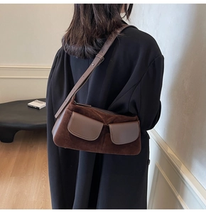 Detail of dark brown matte leather shoulder bag with vintage dual pockets and strap