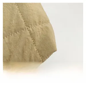 Macro shot of high-quality khaki quilted nylon fabric with detailed diamond stitching