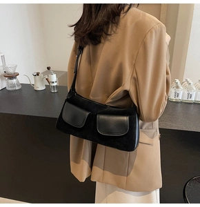 Close-up of black retro matte shoulder bag on a model in a minimalist coffee shop