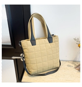 Detail shot of the quilted nylon puffer tote bag with black leather handles and strap