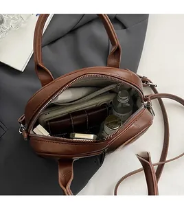 Top view showing the spacious interior of this brown vintage crossbody bag with organized items