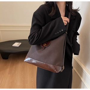 Brown color-block tote bag with matte texture and glossy leather on female model
