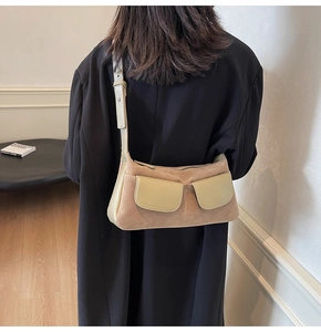Detail of suede and leather shoulder bag with contrast stitching and two front pockets