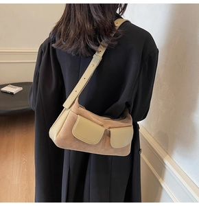 Brown suede crossbody bag worn over a black coat showing its vintage texture and size