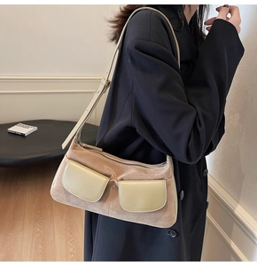 Detail of matte suede and leather contrast on beige shoulder bag with front pockets