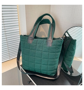 Close-up of dark green quilted nylon tote bag with silver hardware and shoulder strap