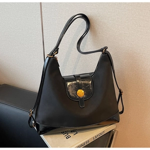 Detail of black nylon tote with leather trim and gold 'N' metal buckle closure