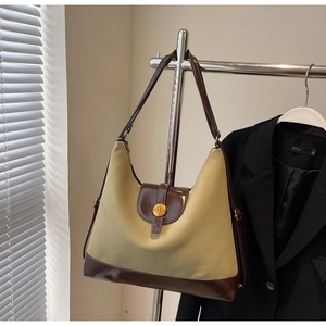 Detailed close-up of retro hobo shoulder bag with olive green panel and gold N-buckle
