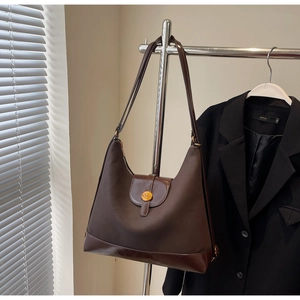Detail of hobo tote bag with canvas stitching, leather base and gold N logo buckle
