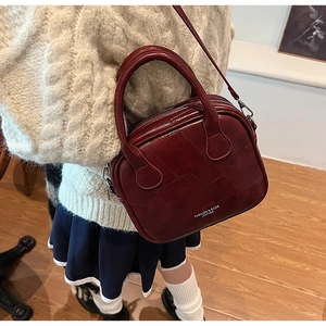 Detail of burgundy vintage square handbag showing faux leather texture and patchwork design