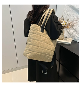 Close-up of beige quilted nylon puffer tote bag with spacious design and black straps