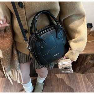 Fashionable black patchwork leather crossbody bag styled with a warm autumn outfit