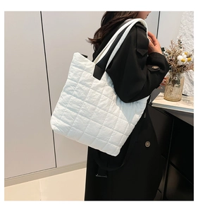 White quilted nylon tote bag worn on shoulder showing large capacity and soft texture