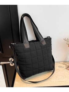 Black quilted nylon tote bag with puffer design and adjustable shoulder strap