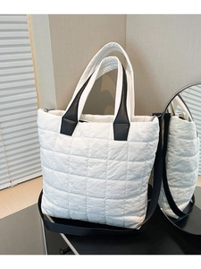 White quilted nylon tote bag with black straps for shoulder and crossbody carry