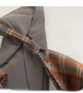 Detailed view of the plaid shoulder strap with orange and blue patterns and visible stitching