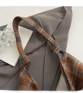 Detail of a plaid woolen tote bag featuring a stylish knotted shoulder strap design