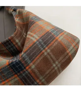 Detail of winter plaid textile fabric with thick orange and grey wool texture