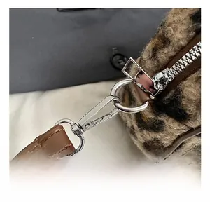 Detail of leopard print plush bag with brown PU strap and silver metal spring hook