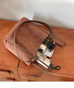 Vue intérieure du grand sac cabas en daim marron avec accessoires du quotidien