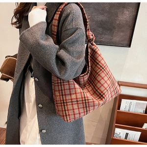 Detail of red and yellow plaid woolen tote bag with shoulder strap knot and soft texture