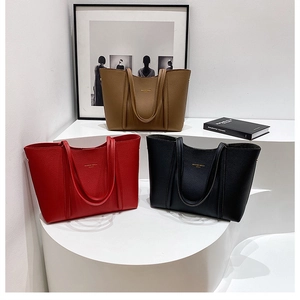 Vista detallada de los bolsos tote en marrón, rojo y negro con textura de cuero granulado