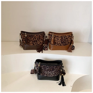 Detailed view of leopard print crossbody bucket bags with fringes in three distinct colors