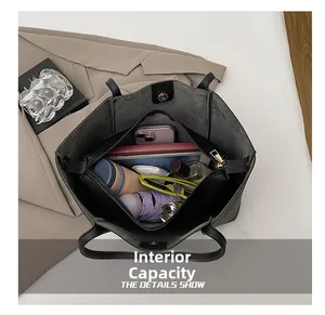 Vista detallada del interior espacioso del bolso tote de cuero negro con cierre de cremallera