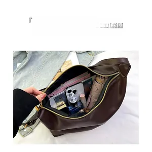 Interior detail of a dark coffee PU leather dumpling bag showing spacious storage capacity