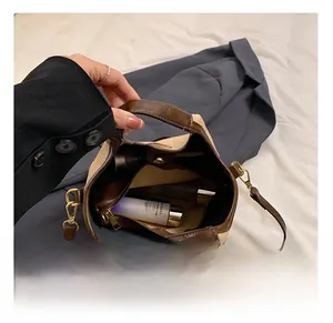 Vue intérieure d'un grand sac seau en toile et cuir marron montrant un rangement spacieux