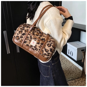 Detail of leopard print plush tote bag with brown faux leather trim and brand patch
