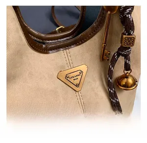 Détail du sac cabas en toile vintage avec logo en métal et pendentif tissé décoratif
