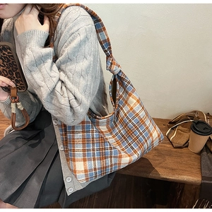 Detail showing the retro plaid wool fabric and stylish knot strap of the tote bag