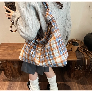 Detail shot of large capacity plaid tote bag with stylish knotted shoulder strap detail