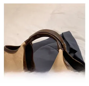 Détail du sac à main bicolore avec poignée en cuir robuste et coutures précises