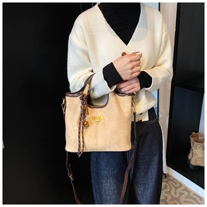 Vue détaillée du sac cabas beige avec logo triangle doré et détails de gland en cuir