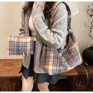 Detail of plaid tote bag set with wide knotted strap and matching zipper pouch