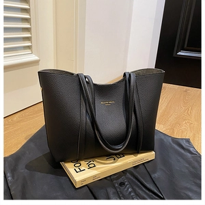 Detalle del bolso tote negro con textura de cuero de grano de lichi de alta calidad
