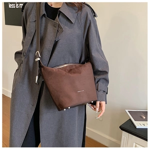 Detailed view of brown matte bucket bag with silver buckles and adjustable strap