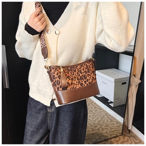 Detail of leopard print bucket bag with wide strap and brown faux leather base