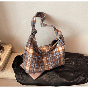 Detail of British plaid tote bag featuring orange and navy fabric and knotted shoulder strap