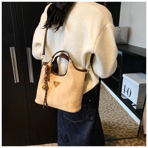 Détail du sac cabas beige et marron avec logo en métal et foulard sur un mannequin