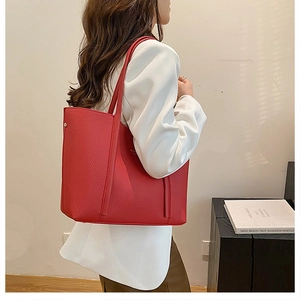 Detalle del bolso tote de cuero granulado rojo con elegantes acabados en color oro