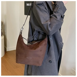 Macro detail of dark brown frosted suede shoulder bag with silver hardware and fashion text